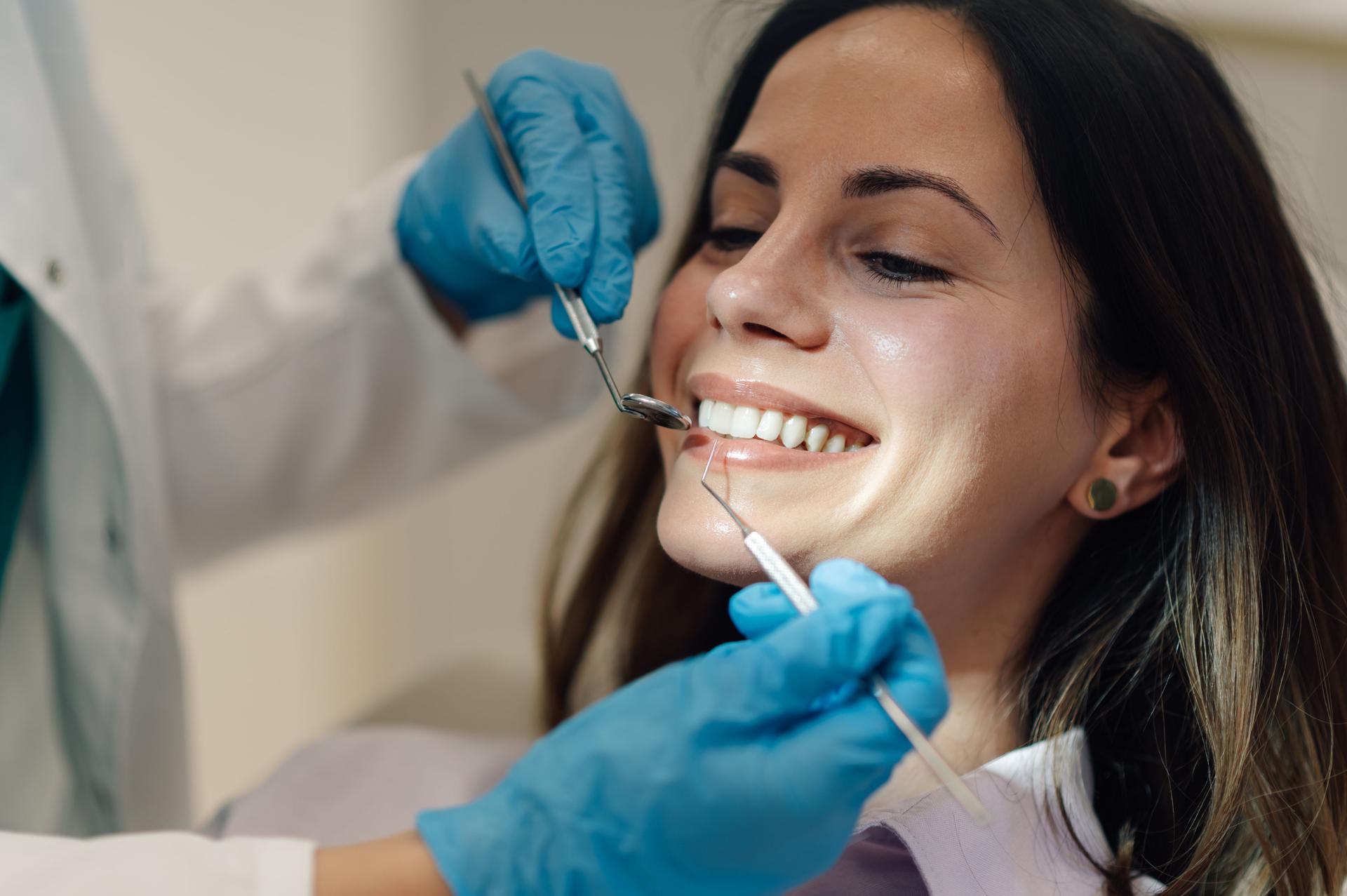 Dentist examining patient's teeth with dental instruments